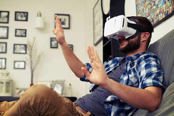 Young man trying to push something wearing virtual reality glass - Foto, immagini