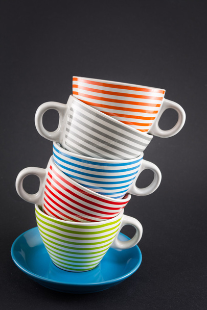 Четыре чашки чая, сложенные на черном
 - Фото, изображение