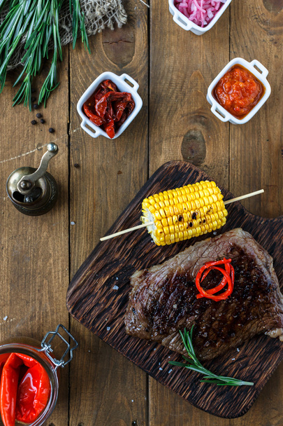 Steak de veau tendre moyen rare avec du maïs et des sauces. Vue du dessus
 - Photo, image