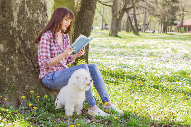 Mooie vrouw ontspannen buiten leesboek - Foto, afbeelding