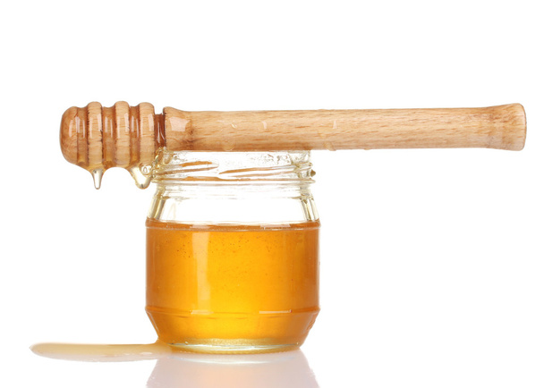 Jar of honey and wooden drizzler isolated on white - Фото, изображение