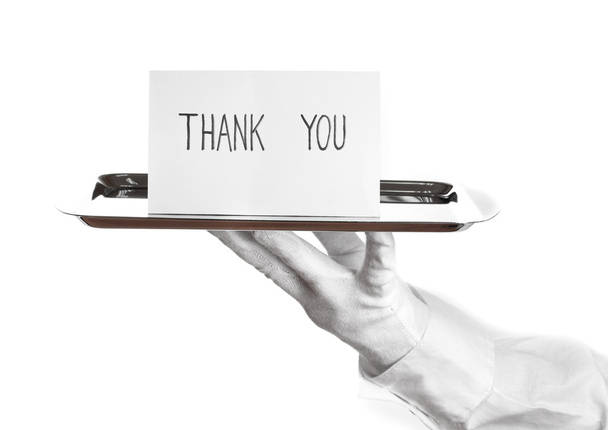 Hand in glove holding silver tray with card saying thank you isolated on white - Zdjęcie, obraz