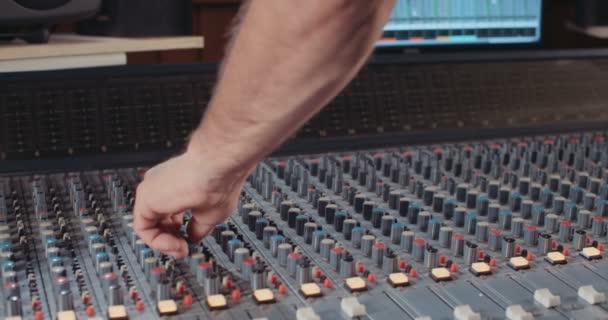 Sound engineer working with a mixing console in a recording studio - Footage, Video