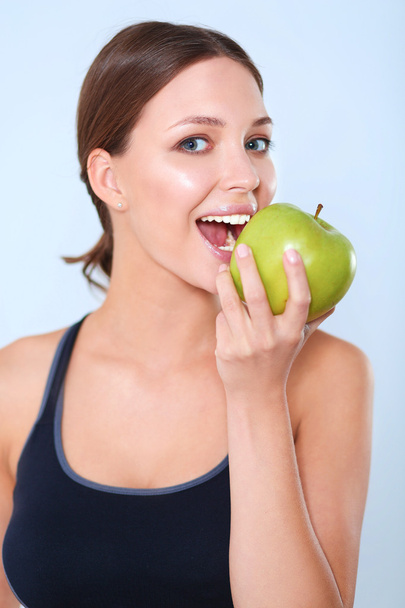 Happy young woman eating apples, isolated on white background - Photo, Image