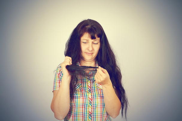 mujer joven mira su cabello problemático
 - Foto, Imagen