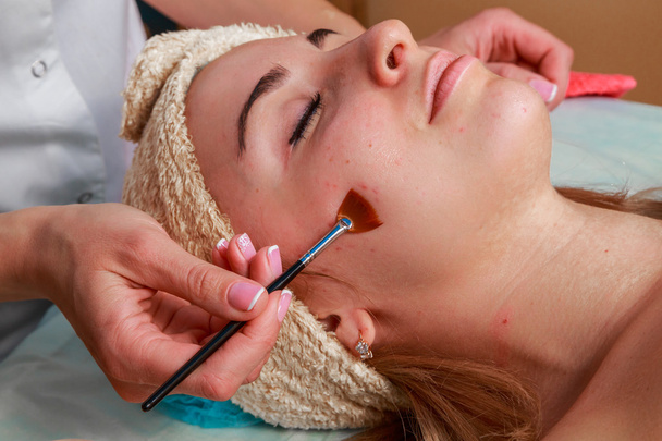 Beauty treatments for problem skin. The girl in the spa salon, applying cream. - Photo, Image
