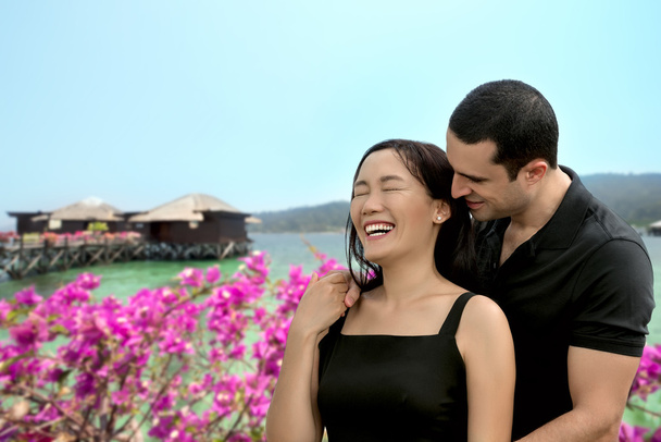 Heureux couple interracial amoureux au bord de la mer avec bungalow
  - Photo, image