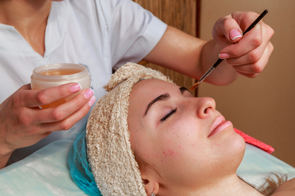 Beauty treatments for problem skin. The girl in the spa salon, applying cream. - Photo, Image
