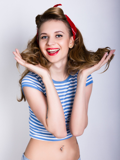 close-up portrait of a beautiful blond in a striped shirt and red scarf, she supports their hands curly hair. Pin Up Girl Concept - Foto, imagen