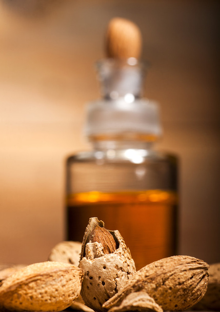 Almond oil on an old wooden background - Photo, Image