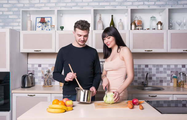 Пара готовит еду на кухне. Беременная женщина
. - Фото, изображение