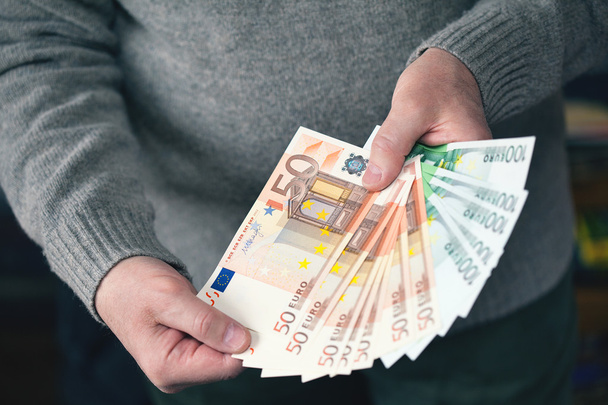 Mannelijke handen met geld in de vorm van een fan. Geld, Euro valuta (Eur) rekeningen - Foto, afbeelding