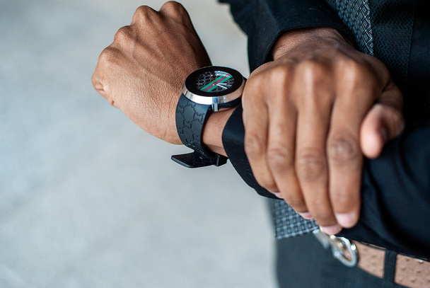 hombre negro con reloj en la mano
 - Foto, Imagen