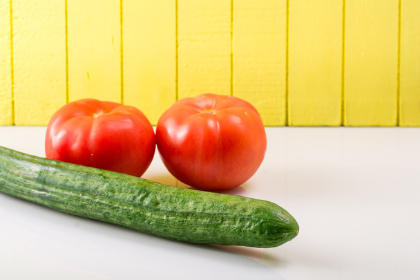 Dos tomates maduros y pepino sobre un fondo claro apoyado
 - Foto, Imagen