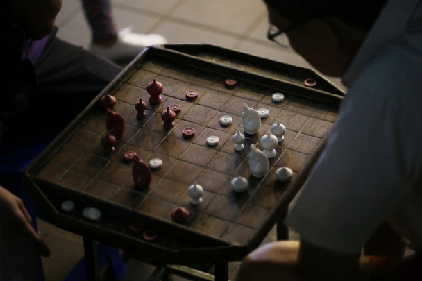 mies pelaa thai shakkia klubilla
 - Valokuva, kuva