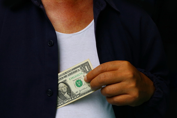 Corrupção. Homem colocando dinheiro no bolso jaqueta terno
 - Foto, Imagem