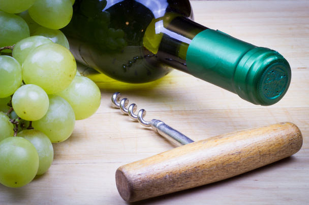 Bottiglia di vino bianco dolce con uva fresca sul vecchio tavolo di legno
 - Foto, immagini