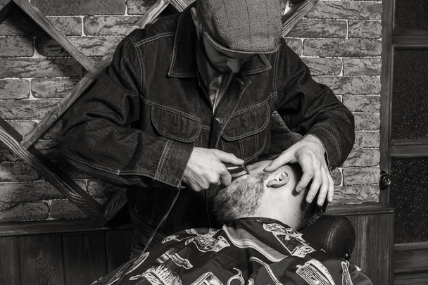 Парикмахерская. Парикмахеры, парикмахеры. Парикмахер режет клиента ножницами
. - Фото, изображение