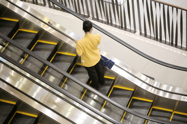 femme de ménage nettoie escalator
 - Photo, image