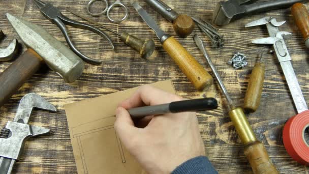 Man draws a draft. Indicates dimensions. Vintage tools on background - Footage, Video