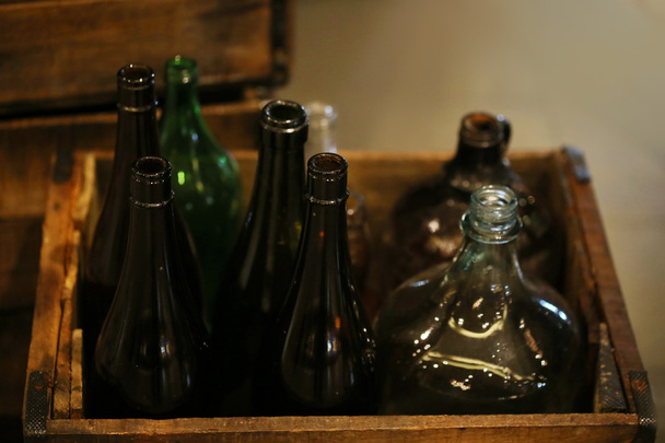 πολύχρωμο παλιό γυάλινο μπουκάλι σε ξύλινο κουτί - Φωτογραφία, εικόνα