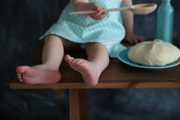 Dziewczynka dziecko piekarz z płyty ciasta, na tle czarnego bord - Zdjęcie, obraz