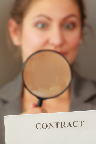Business woman with contract and loupe - Foto, Imagen