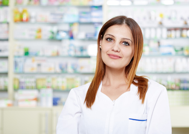 woman pharmacist over blurred background of shelves - Foto, Imagem