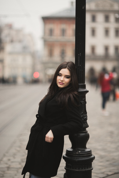 Beautiful brunette young woman posing on the street in old city - Φωτογραφία, εικόνα