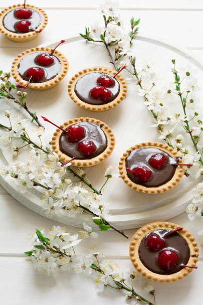 Mini tarts with chocolate and cherries decorated cherry blossom - Foto, imagen