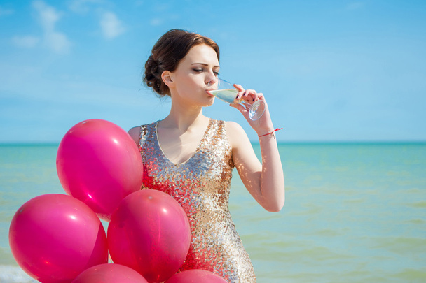 жінка з повітряними кулями на морі
 - Фото, зображення