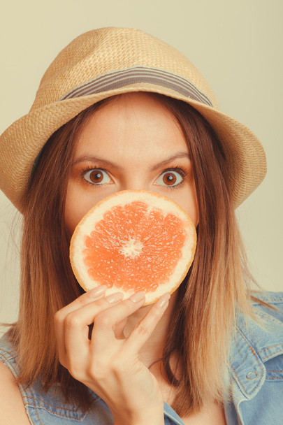 Woman covering her mouth with grapefruit. Fun summer - 写真・画像