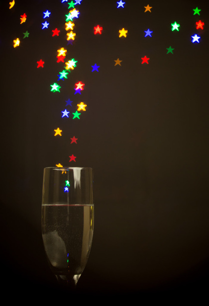 star shape bokeh lights floating out of Champagne glass - Foto, imagen