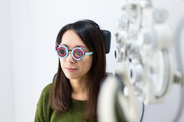 Frau macht Sehtest in optischer Klinik - Foto, Bild