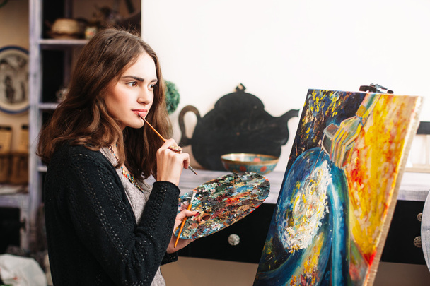 Creative pensive painter paints a colorful picture - Photo, Image