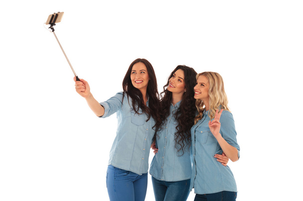 3 lässige junge Frauen machen ein Selfie mit ihrem Handy - Foto, Bild