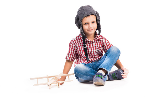 маленький мальчик в шляпе пилота и игрушечном самолете
 - Фото, изображение