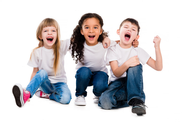 трое смешных детей смеются сидя на полу
 - Фото, изображение