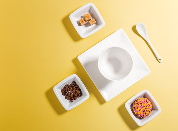 Beyaz porselen kahve çekirdekleri, şeker ve kek üzerine Üstten Görünüm - Fotoğraf, Görsel