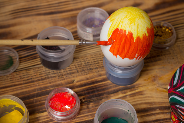 process of paiting easter egg with orange brush, cans, wood - Foto, imagen