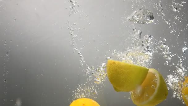 Partes de gotas de limón bajo el agua. Fondo gris
 - Metraje, vídeo