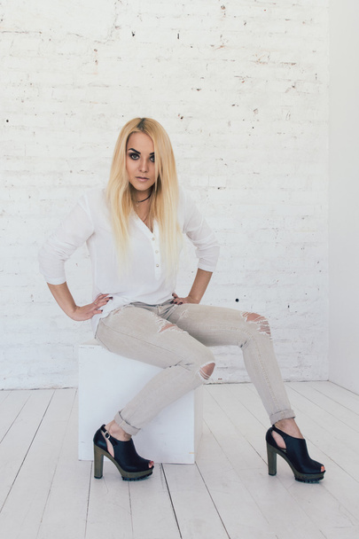 Young sexy blond woman in white shirt and jeans and black shoes - Fotografie, Obrázek