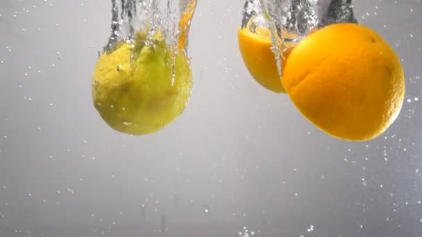 Limão e laranja caem na água em câmera lenta
 - Filmagem, Vídeo