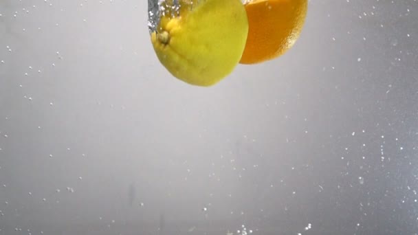 Limón y naranja gotas en el agua en cámara lenta
 - Imágenes, Vídeo