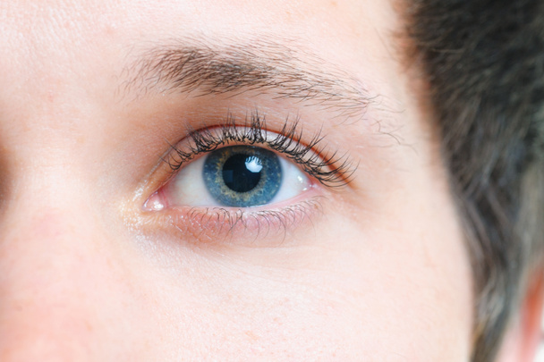 Nahaufnahme von blauen Augen eines jungen Mannes - Foto, Bild