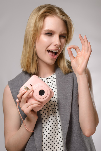Kaunis blondi tyttö vaaleanpunainen kamera nauraa ja hymyilee
 - Valokuva, kuva