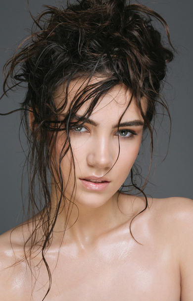 Sexy brunette woman with wet hair beauty on grey - Foto, afbeelding