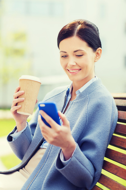 smiling woman with coffee and smartphone - Photo, image