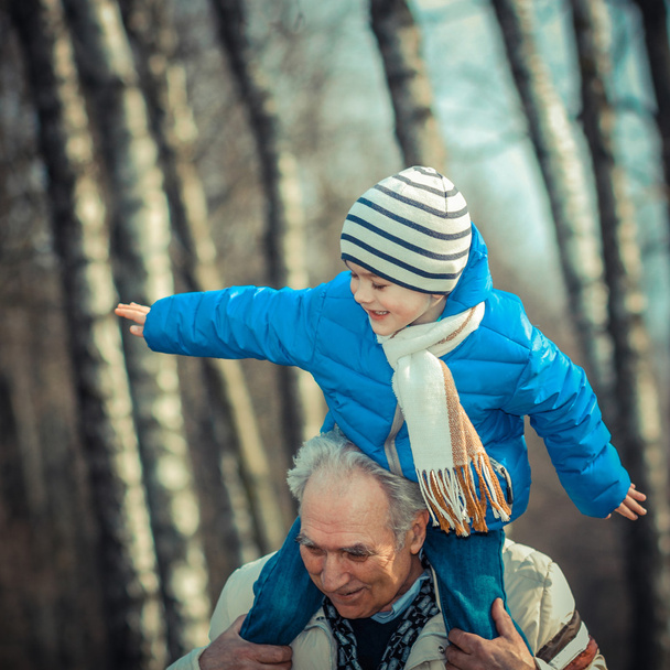 Großvater trägt Enkel auf seinen Schultern  - Foto, Bild