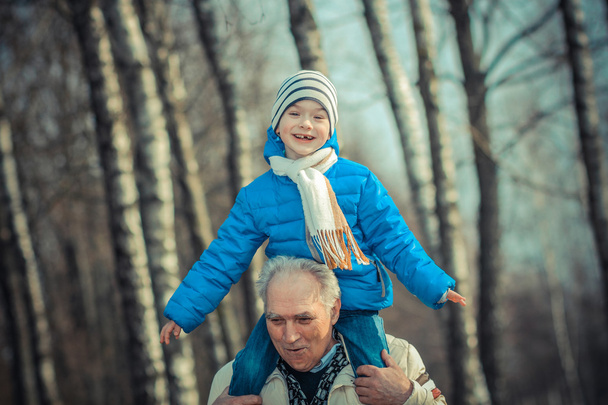 Abuelo lleva nieto sobre sus hombros
  - Foto, Imagen
